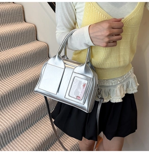 Detail of silver metallic handbag with rabbit card holder shown on casual outfit