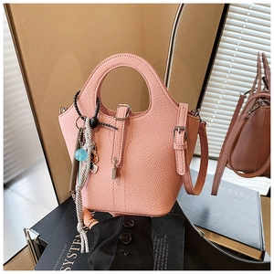 Close-up of pink bucket bag showing lychee grain leather texture and metal buckle