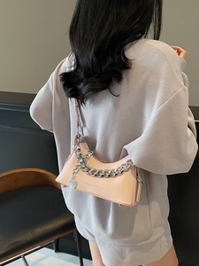 Glossy pale pink crescent shoulder bag with bold silver chain and metal zipper
