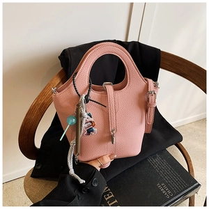 Detail of pink lychee grain bucket bag with charms and adjustable shoulder strap