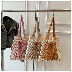 Close-up of summer knit mesh tote bags featuring colorful bead accents and long handles
