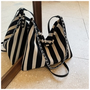Detail of striped canvas tote showing woven chain strap and durable fabric texture