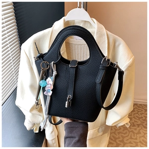 Detail of black lychee grain leather bucket bag with silver lock and round hollow handle