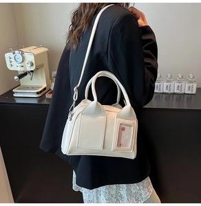 Detail of off-white leather Boston bag with cat-ear flap and transparent card slot