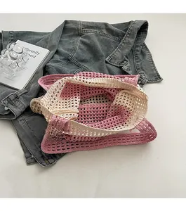 Detail view of pink and beige hollow mesh shoulder bag in a casual lifestyle setting
