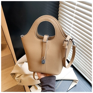 Detail of khaki pebbled leather bucket bag with metal padlock and round top handle
