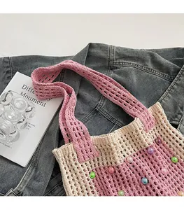 Close-up of pink and beige woven shoulder bag with colorful beads and mesh texture