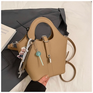 Macro detail of khaki leather bucket bag with litchi texture and silver padlock