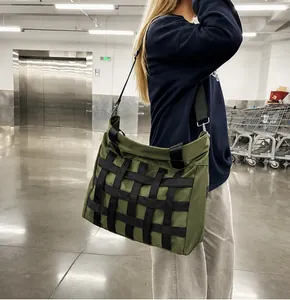 Detail of army green nylon crossbody tote with black webbing and wide shoulder strap