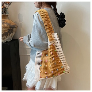 Detail of hand-crocheted tote bag with contrast stitching and colorful bead accents