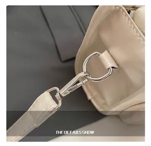 Detail showing premium silver metal hook and D-ring on beige leather bowling handbag