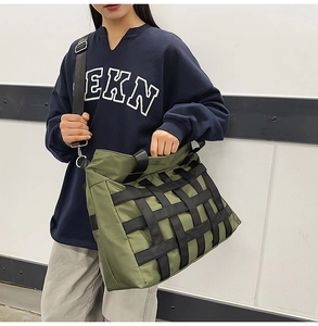 Detail of army green nylon crossbody bag with black webbing pattern on male model