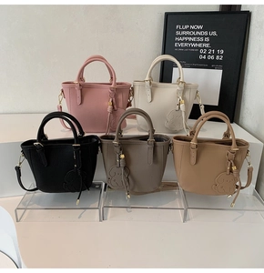 Detailed view of luxury pebbled leather tote bags in five colors with dog charm decorations