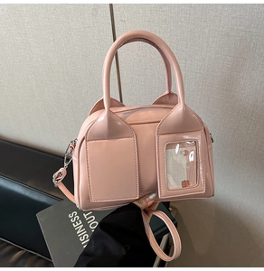 Close-up of pink patent leather handbag with cat ear details and crossbody strap