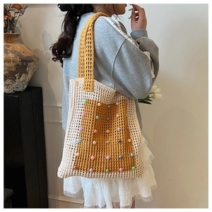 Detail of handmade crochet tote bag featuring two-tone knit patterns and colorful bead accents
