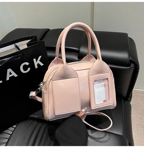Detail of light pink mini pillow bag with card slot on black leather sofa background