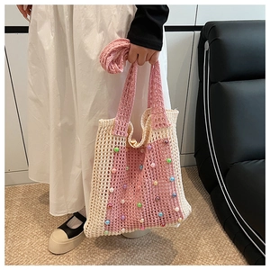 Detail of hand-woven hollow knit bag with colorful beads and beige pink patchwork
