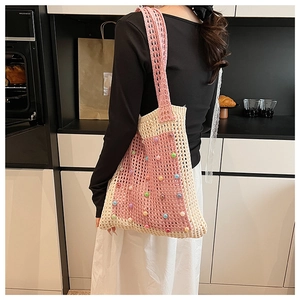 Detail of hand-crocheted mesh tote bag with colorful beads and wide knit shoulder strap