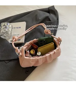 Pink pleated cloud bag detail showing large internal capacity for phone and cosmetics