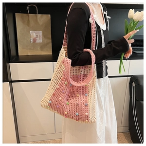 Detail of hand-woven hollow mesh bag featuring pink patchwork and colorful pearls