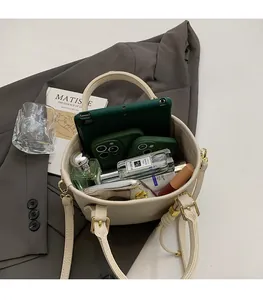 Macro view of spacious interior of cream bucket bag with tablet and cosmetics