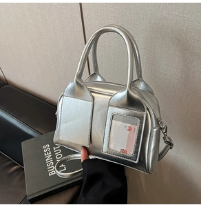 Dettaglio borsa a bauletto argento con doppi manici e fessura per tessera a coniglio