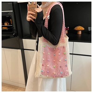 Detail of pink and beige crochet tote bag with colorful pearl embellishments