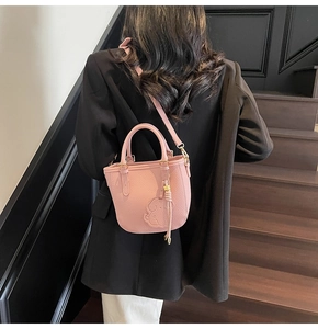 Pink lychee texture bucket bag featuring cute puppy embossing and matching charm detail