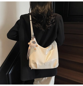 Dettaglio borsa hobo bianco crema morbida con ciondolo alpaca e finitura lucida