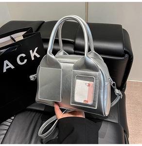Detail of silver metallic Boston bag featuring transparent card slot and textured finish
