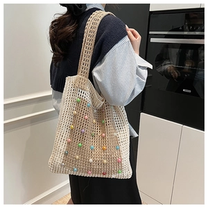 Detail of knit mesh tote bag with colorful faux pearls and wide shoulder strap