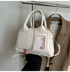 Dettaglio della borsa a bauletto in pelle lucida bianco crema con tasca trasparente e coniglio