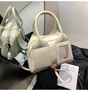 Dettaglio della borsa boston bianco crema con tasche e tracolla staccabile