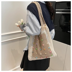 Detail of beige crochet tote bag with colorful pearls and hollow knit texture