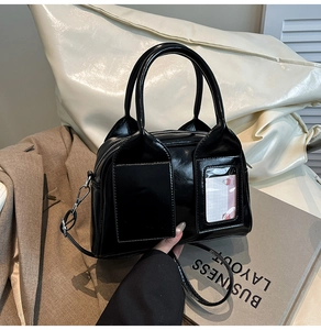 Dettaglio borsa a bauletto in pelle verniciata nera con scomparto per carte trasparente