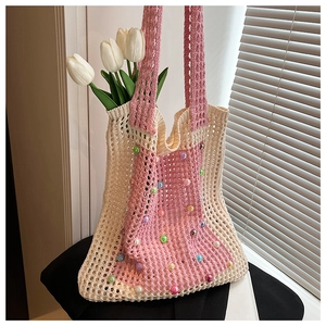 Close-up of cream and pink knit tote bag featuring colorful faux pearls and floral accents
