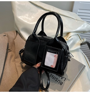 Dettaglio borsa a bauletto in pelle lucida nera con fessura per carte e fibbie argentate
