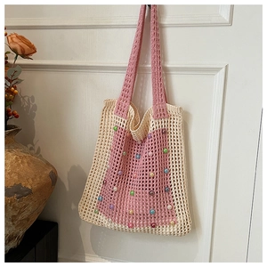 Detail of hand-knitted crochet shoulder bag featuring colorful pearls and mesh pattern
