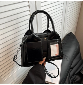 Close-up of black patent leather Boston bag with cat-ear handle base and card holder