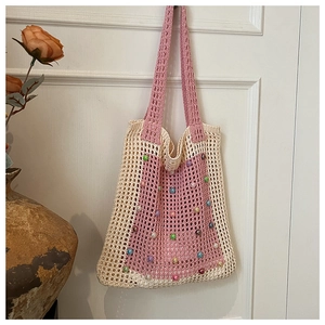 Detail view of handmade knit tote bag showing intricate crochet patterns and colorful beads