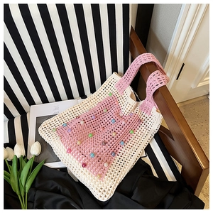 Detailed close-up of handmade knit tote bag featuring colorful bead accents and pink trim