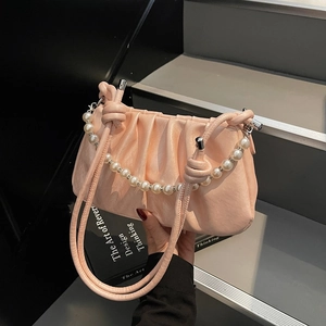 Detail of ruched apricot cloud bag with pearl chain strap and knotted handles