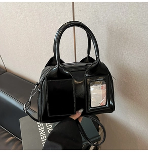 Close-up of black glossy bowling bag with twin handles and transparent card pocket detail