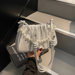 Silver pleated crossbody bag with pearl chain detail and glossy metallic finish texture