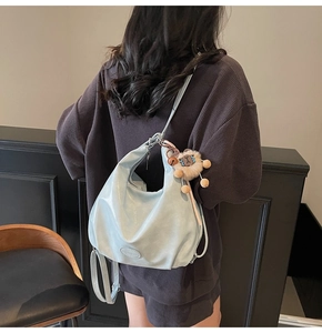 Dettaglio della borsa hobo azzurra in pelle lucida con ciondolo a forma di leone