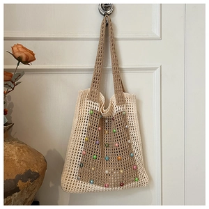 Close-up of hand-woven hollow tote bag with colorful beads and minimalist design