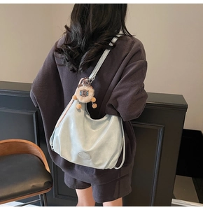 Dettaglio della borsa tote in morbida pelle azzurra con un simpatico ciondolo a leone
