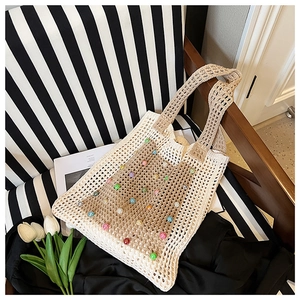 Detail of knit tote bag with colorful pearl beads and bohemian crochet texture