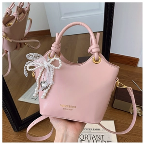 Detail der rosa Kunstleder-Beuteltasche mit Knotengriff und Perlenspitzen-Anhänger