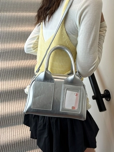 Borsa a bauletto argento metallizzato con fessura per carte in un ambiente lifestyle